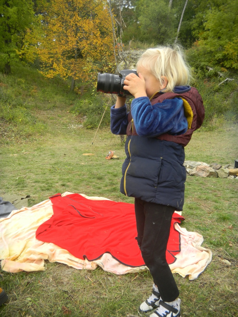 Holčička fotí fotoaparátem.